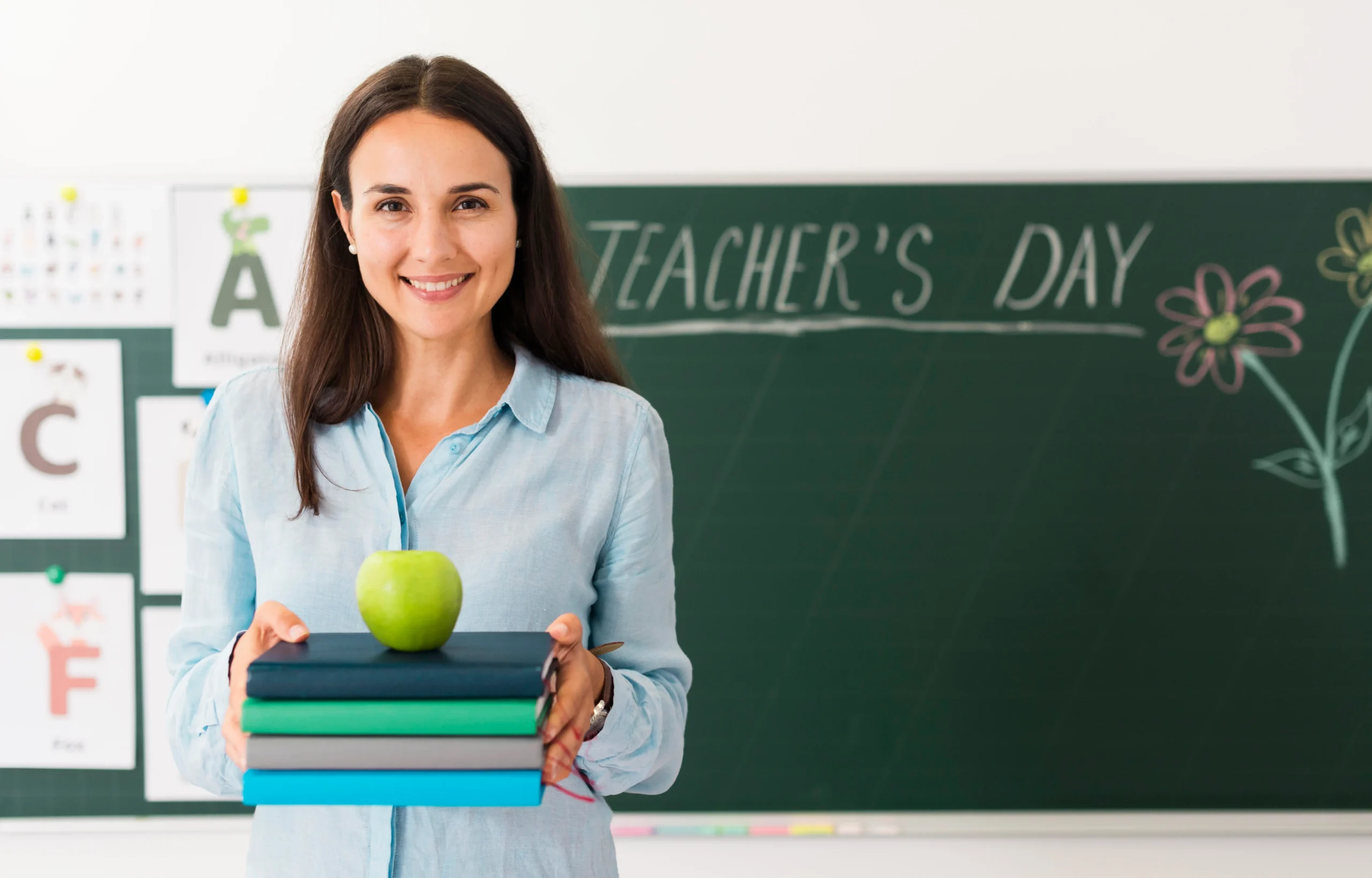 Smiley teacher holding bunch books apple with copy space